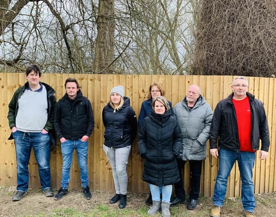 Warsop residents, photographed at the bottom of Wood Street, against the newly erected fence on green space by the river Meden.