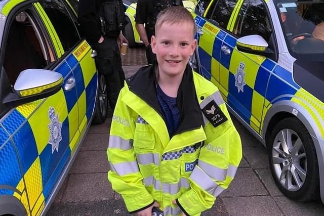 A youngster tries a police jacket for size.