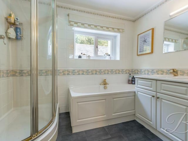 The first floor at Church Hill also houses this splendid family bathroom. It comes complete with a panelled bath, wash hand basin with vanity storage, enclosed shower and full-height tiling.