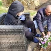 A family member and staff planting flowers in the memorial garden.