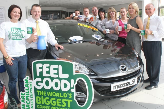 Rebecca Staden, Macmillan Nurses Fund Raiser, and Keel Bentham, GK Ford, left, with GK staff at the Macmillan Coffee morning in 2009