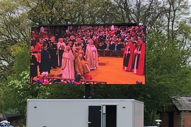 The coronation events unfolding on the big screen at Thoresby Park's celebration event.