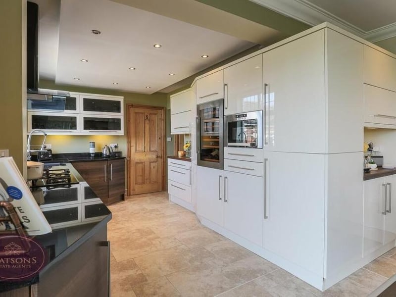 Next stop is the L-shaped, contemporary kitchen. Integrated appliances include an electric oven and gas hob with extractor over, fridge freezer, waist-height microwave, dishwasher and wine cooler. Underfloor heating, ceiling spotlights and a high-quality laminate wood flooring are other notable features.