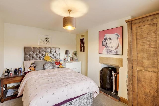The second double bedroom is slightly smaller than the first, but still a comfortable space. It features a recessed chimney-breast alcove with tiled hearth, carpeted floor and wood-framed sash window.