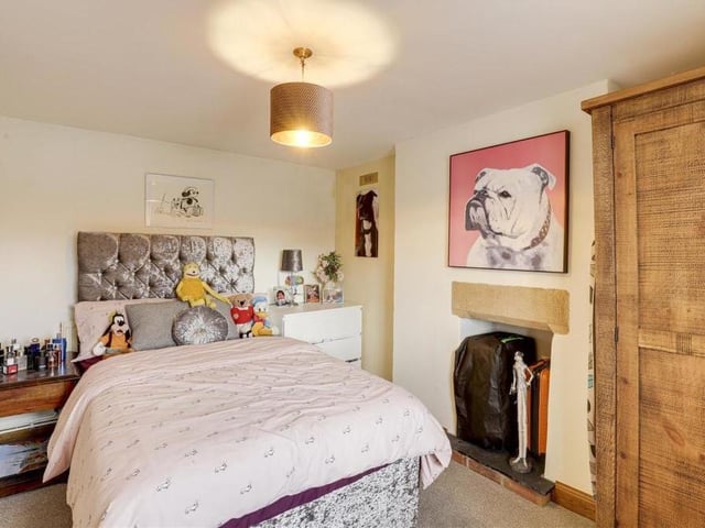 The second double bedroom is slightly smaller than the first, but still a comfortable space. It features a recessed chimney-breast alcove with tiled hearth, carpeted floor and wood-framed sash window.