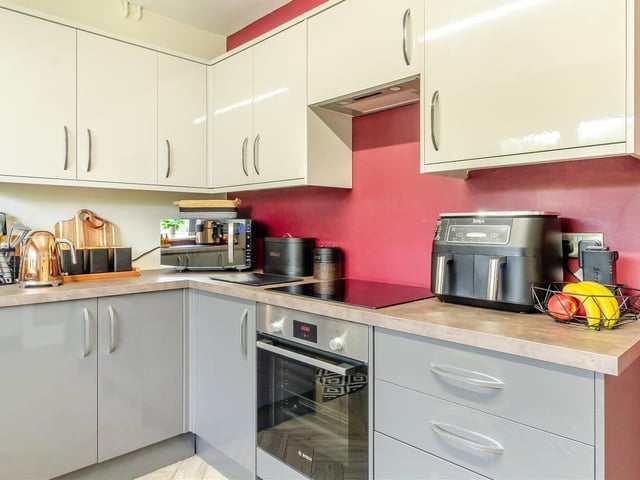 A close look at the contrasting units in the kitchen. A host of integrated Bosch cooking appliances include a fan-assisted electric oven, and four-ring induction hob with extractor hood above.