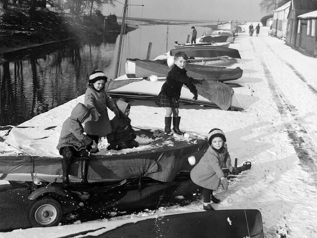 Children playing on snow-covered boats at Cramond in 1963.