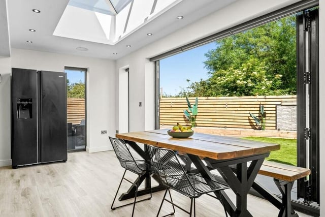 The dining area of the open-plan kitchen sits in front of large bi-folding doors that open out on to the rear garden.