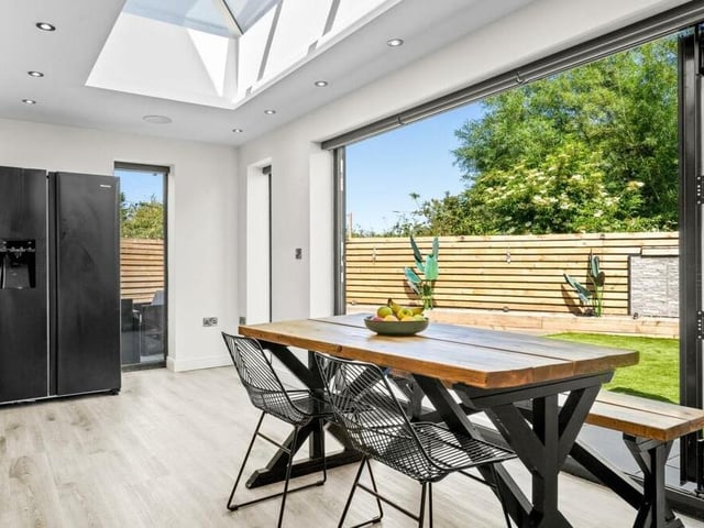 The dining area of the open-plan kitchen sits in front of large bi-folding doors that open out on to the rear garden.