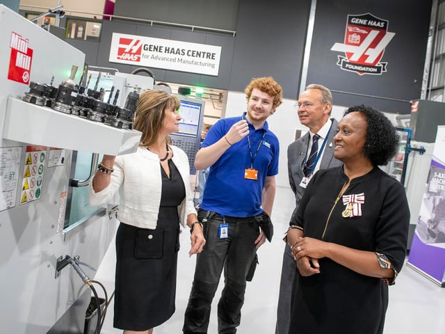 Glenair UK apprentice Lewis Edmunds demonstrates a Haas CNC mini mill to Kathy Looman, Andrew Cropley and Professor Pickering.