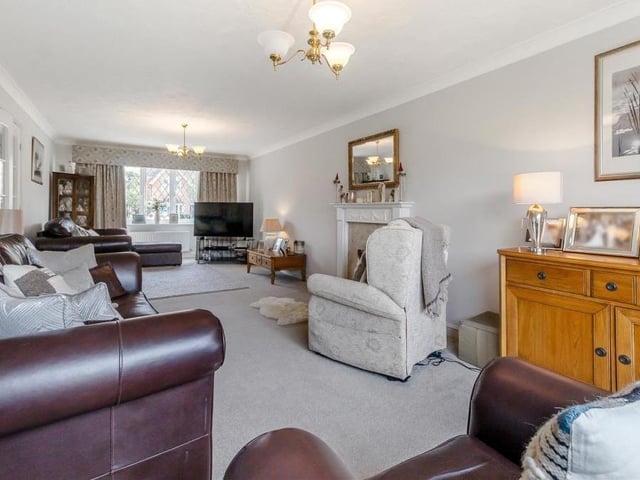 A shot of the lounge from the opposite end of the room, underlining the comfort and space it offers. There is coving to the ceiling and, at the far end, a double-glazed bay window.