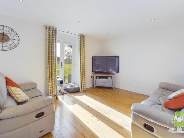 This is the lounge or living room section of the open-plan ground floor.The double doors lead out to the community grounds of the complex and a patio.