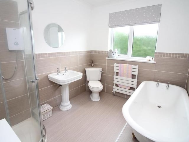 Here is the main family bathroom, which can be found on the first floor of the Eastwood property and has been recently re-fitted. A white four-piece suite comprises a free-standing, roll-top bath, a corner shower cubicle with electric shower over, a pedestal sink unit and a WC. There are also a chrome, heated towel-rail and ceiling spotlights.