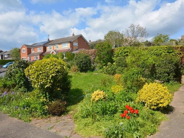 Let's step outside now and enjoy the gardens, which can be found at the front and back of the bungalow. They feature a wide selection of plants, shrubs and mature trees.