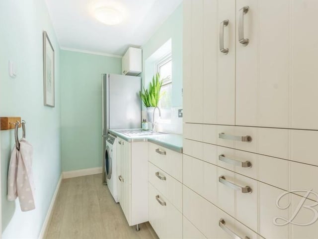 This utility room is a handy extension to the kitchen, with its matching wall and base units, worktop and inset sink and drainer. There is space and plumbing for a washing machine, and space for a full-sized fridge/freezer