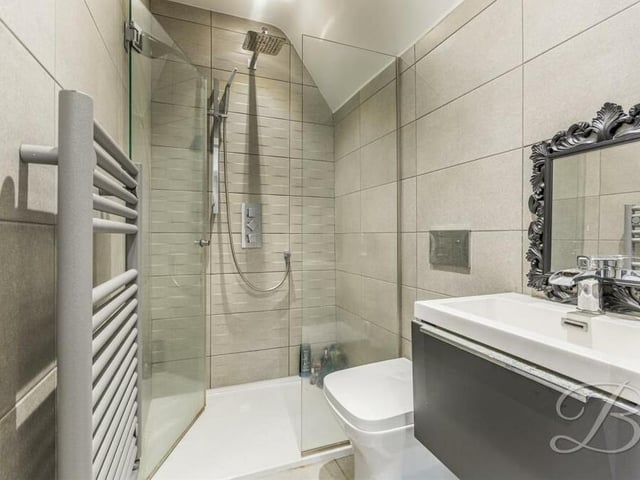In a house boasting FOUR bathrooms, here is the third en suite, with walk-in shower, wash hand basin with vanity storage, low-flush WC and heated towel-rail.