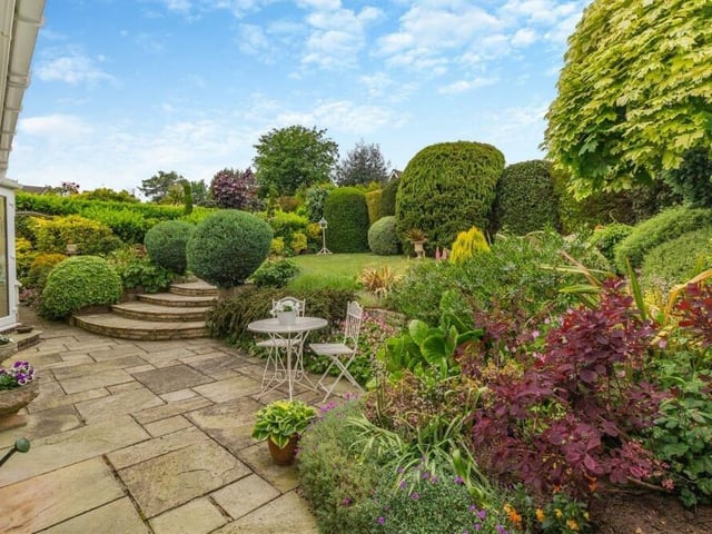 Another shot of the rear garden from the extensive main patio. Shrubs, plants, bushes and borders abound.