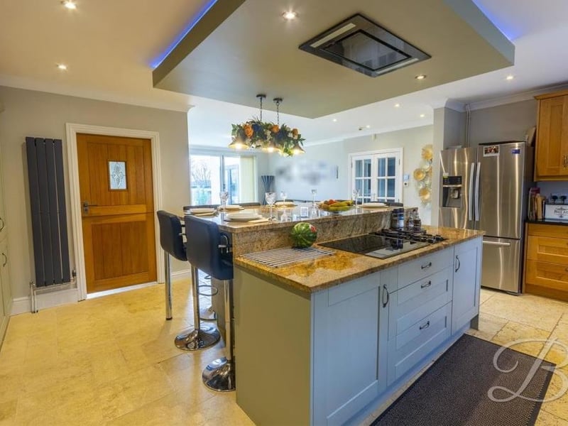 A close-up of the kitchen island. In the background, a set of sliding doors leads out to the garden.