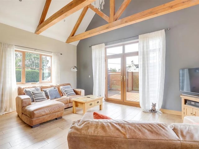 The stunning living room has French doors opening onto the front garden and has stunning vaulted ceilings.
