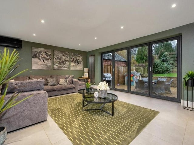 Other features of the lounge include aluminium bi-folding doors that open out on to the rear garden, and a wall-mounted Mitsubishi air-conditioning unit.