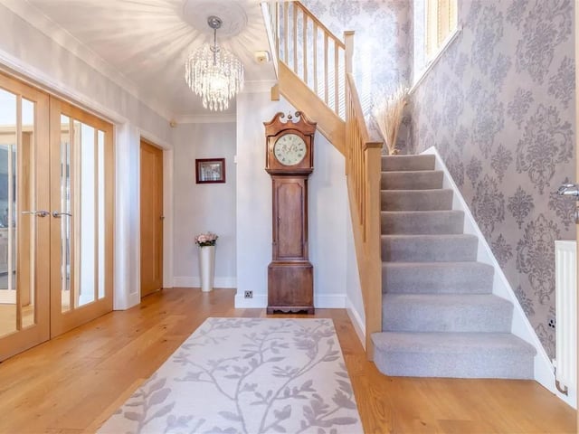 A spacious and wide entrance hall with oak floor, vertical radiator, coving to ceiling, understairs storage cupboard and stairs leading to the first floor landing.