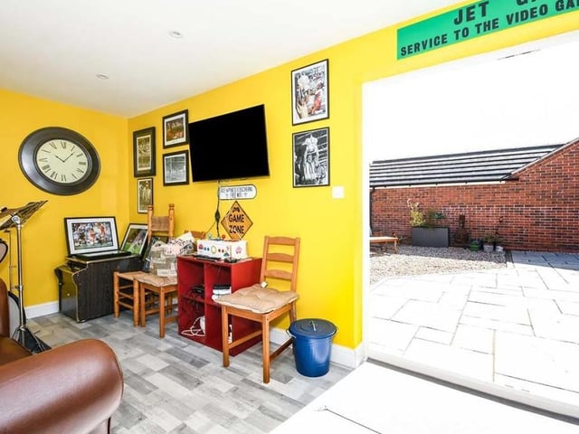 And here is the coup de grace - the section of the property's garage that has been turned into a bar, with French doors opening out on to the back garden. Get the drinks in!