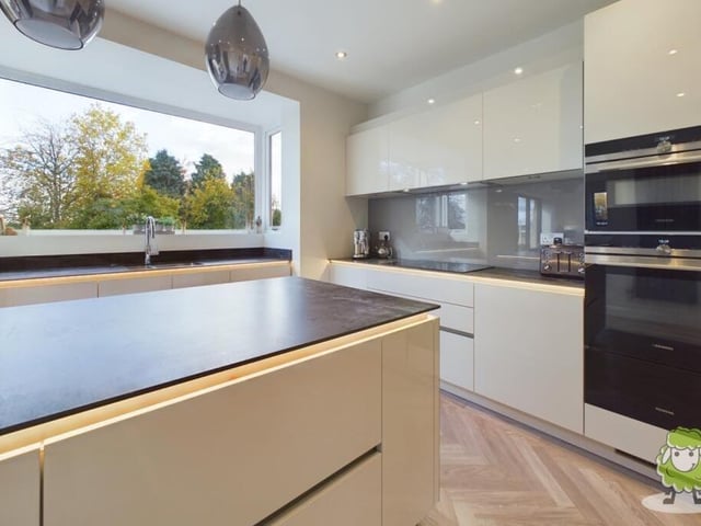 The kitchen includes a central island and contemporary, high-quality appliances.