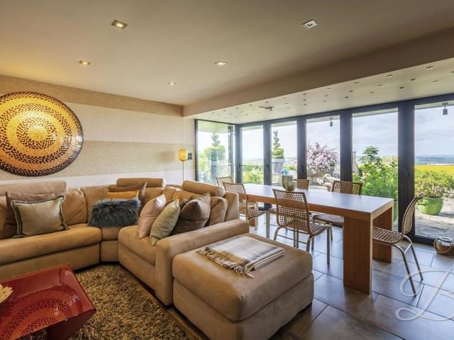 Time to slide downstairs, where the main focal point of the £400,000 bungalow is this spectacular garden room, with a living and dining area that opens out to the back garden patio thanks to glass bi-fold doors.