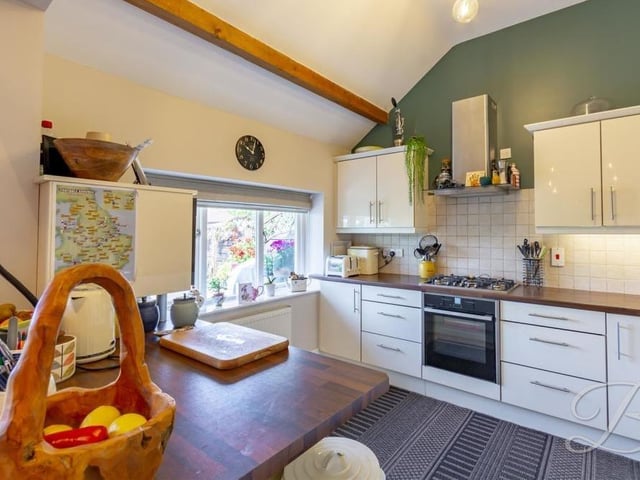A second glance of the kitchen, which includes an integrated fridge freezer and oven. The window faces the front of the property.