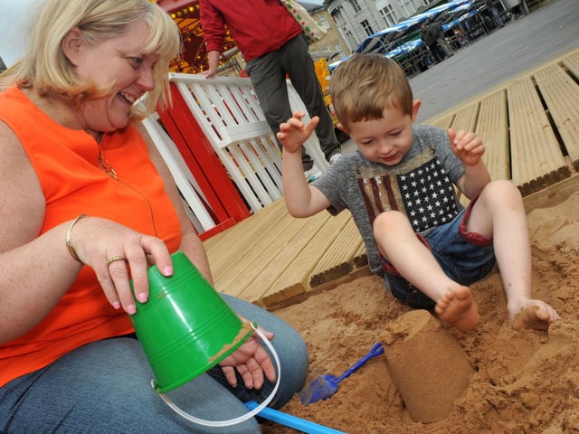 Janet Findlay helps grandson Jack Matheson build sand castles during their visit to the Mansfield beach