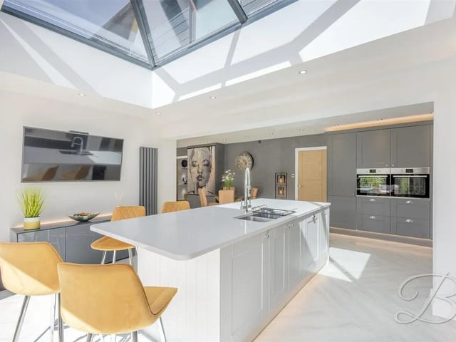 This beautifully designed open-plan layout features a range of high-end cabinetry, integrated appliances, and an elegant inset sink. At the heart of the space is a striking feature island, perfect for both entertaining and casual dining.