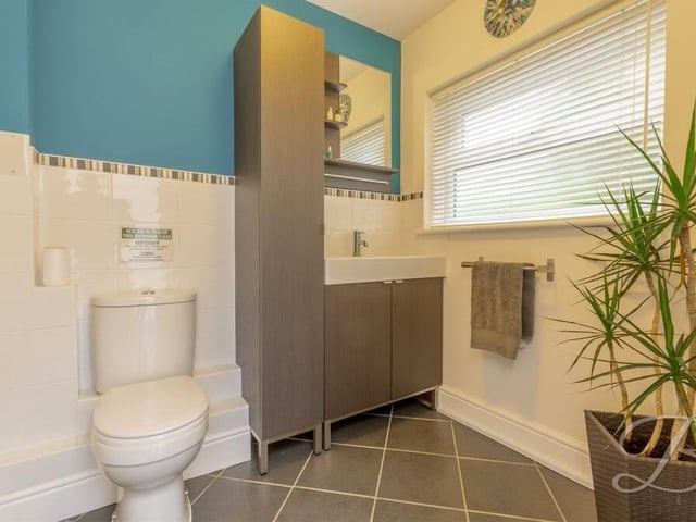 Here is the smart downstairs toilet. It comprises a low-flush WC, wash hand basin, vanity storage and full-height tiling.