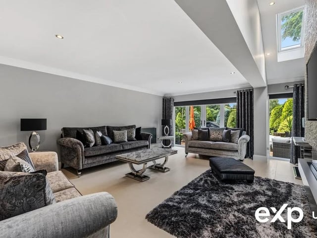The décor is finished with sleek tiled flooring and dominated by a feature media wall with a slate surround detail and an electric fire. Double doors open to the rear patio alongside windows that take in the garden outlook with two Velux windows adding to the ambience.