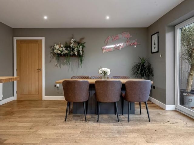 Part of the kitchen at the £470,000 property is taken up by this dining area, with a fitted banquet-style table and seating and matching solid-wood top.
