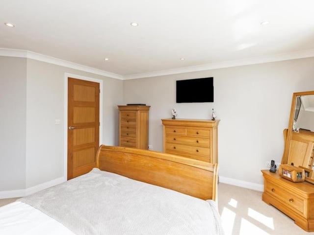 A second shot of the master bedroom. The floor is carpeted, and there is access to a walk-in wardrobe and en suite facilities.
