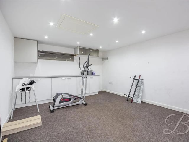 The exterior consists of two large outbuildings, one of which includes a small kitchen area, perfect for a home gym, hobby room or additional living area.