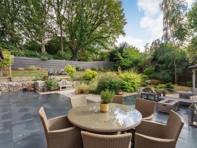 Another photo of the main patio area, with raised sleeper flowerbeds in the background and a summerhouse to the right.
