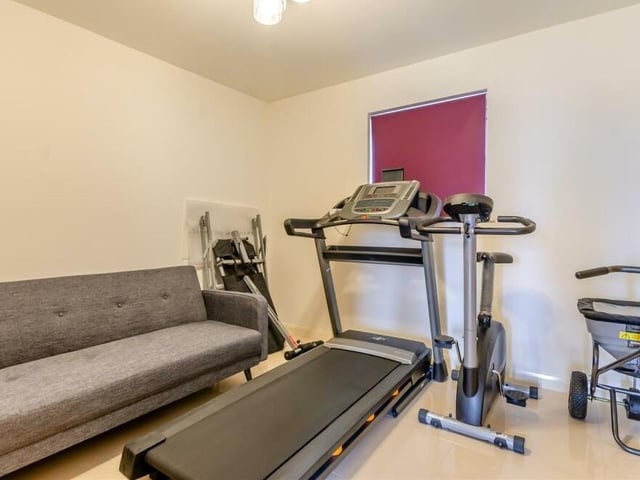 This ground-floor space has been turned into a gym, but it could easily function as the Sutton property's fifth bedroom. Like the rest of the ground floor, it boasts a porcelain tiled floor and underfloor heating.