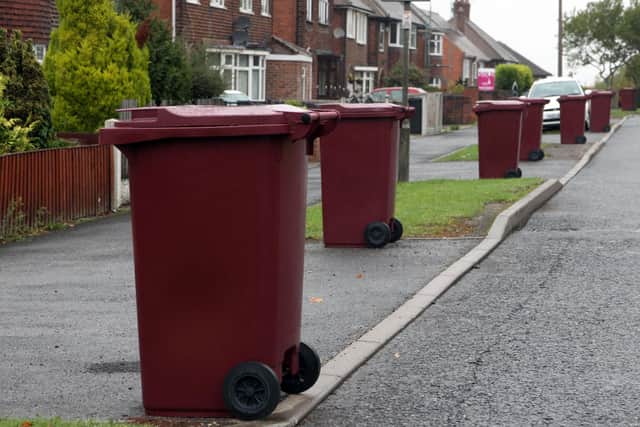 Burgundy bins in a street awaiting collection