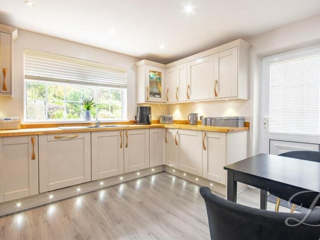 Next stop is the stylish kitchen, which comes complete with shaker-style wall and base units, work surfaces of natural wood and an inset sink with a mixer tap above