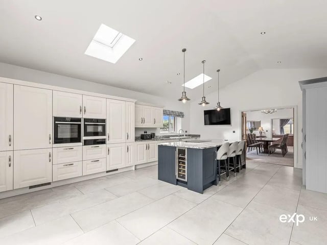 Quality appliances include an integrated oven, an integrated microwave oven, and a warming drawer. There is also an integrated dishwasher and a full-height fridge and freezer. This pristine kitchen has a place for everything.