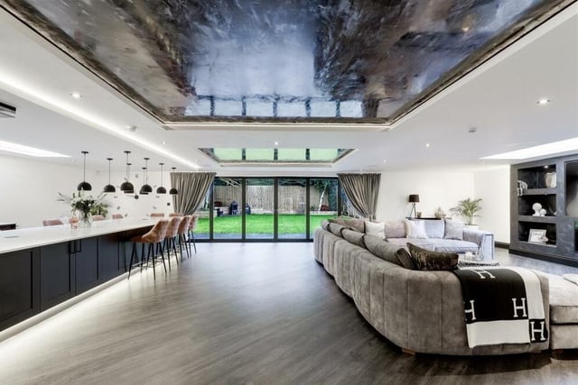 An amazing ceiling, with LED light boxes, hangs over the open-plan kitchen and living area.