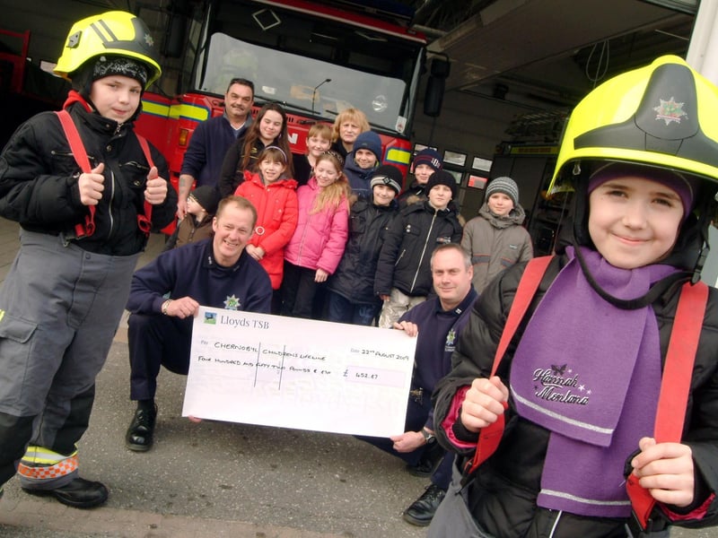 Mansfield and Ashfield Link of The Chernobyl Children's Life Line visited Mansfield Fire Station in August, 2010. Chernobyl youngsters Tetyana Rudenko 10, right and Sasha Veason 12, left got dressed up for the occasion while fire fighters, Watch Manager Alan Henstock, knelt left, and Crew Manager Pete Brown, knelt right presented £452.87 from a car wash held to support the charity.