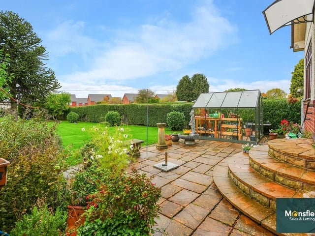 The stunning rear garden is a standout feature — a beautifully maintained space with a large lawn and patio seating area, perfect for outdoor entertaining or peaceful relaxation.