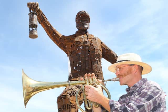 Sculptor Phil Neal played the miners' hymn for those attending.