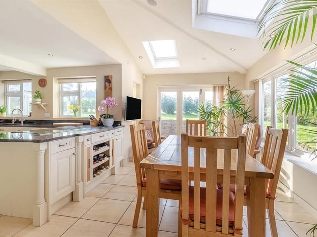 The home has a superb, light and airy, L-shaped open plan dining kitchen featuring contemporary wall cupboards including display cabinets and shelving with inset spotlights. Integrated appliances include Neff twin ovens, steam oven and microwave. Integrated AEG induction hob with De Dietrich down draft extractor. Integrated fridge/freezer. Tiled floor, underfloor heating and four surround sound ceiling speakers. The dining area has a 10'5" vaulted high ceiling with three electric velux roof windows with blinds. Double glazed windows with lovely aspects overlooking the rear garden, and contemporary bi-folding doors leading out onto the rear garden.