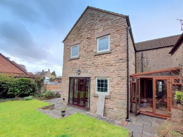 The cottage is an attractive sight at the back, as well as at the front. Here you can see the rear entrance and also the large doors that open out from the breakfast kitchen.