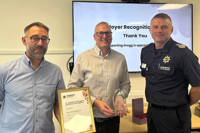 Firefighter Greg Leliwa and Eastwood firm Race Technology Ltd receive awards from CFO Craig Parkin. Photo: Submitted