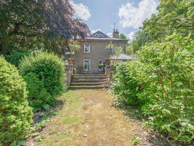 You've seen the front of the property, now check out the back, which shows how steps lead down from the patio to a lawned back garden flanked by mature shrubs and trees.
