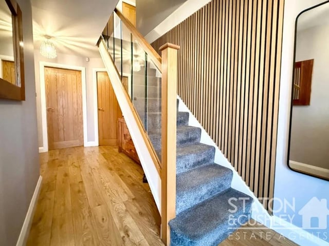 Upon entering, you are greeted by a bright and welcoming entrance hallway, featuring a contemporary glass balustrade staircase that sets the tone for the rest of the home